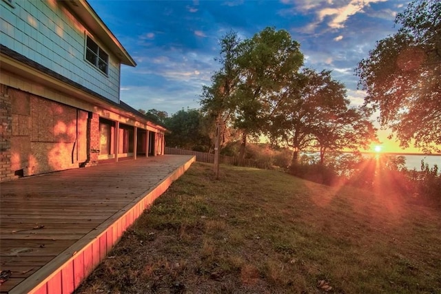 yard at dusk featuring a wooden deck