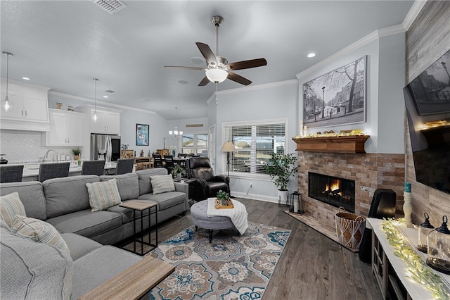 living room with ceiling fan, a fireplace, dark wood-type flooring, and ornamental molding