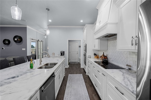 kitchen featuring dark wood-type flooring, white cabinets, sink, appliances with stainless steel finishes, and decorative light fixtures