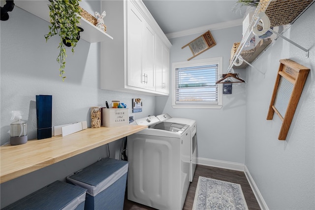 laundry room featuring cabinets, ornamental molding, dark wood-type flooring, and washing machine and clothes dryer