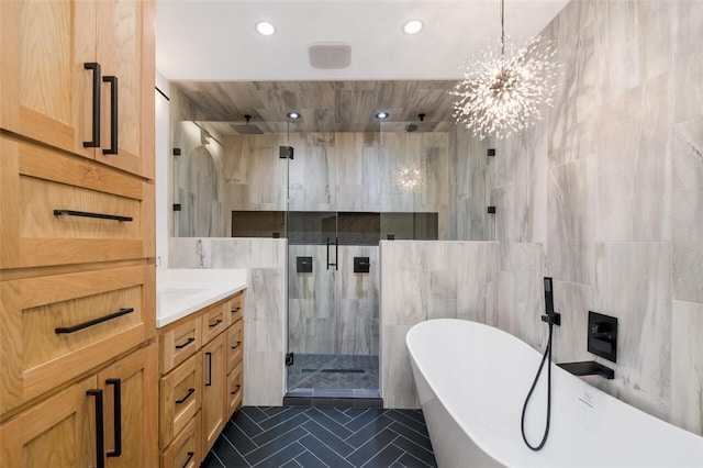 bathroom with vanity, tile patterned flooring, separate shower and tub, tile walls, and a chandelier