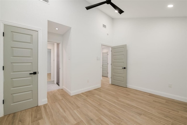 unfurnished bedroom with ceiling fan, high vaulted ceiling, and light hardwood / wood-style flooring