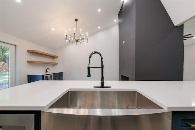 kitchen with sink, blue cabinets, kitchen peninsula, pendant lighting, and lofted ceiling