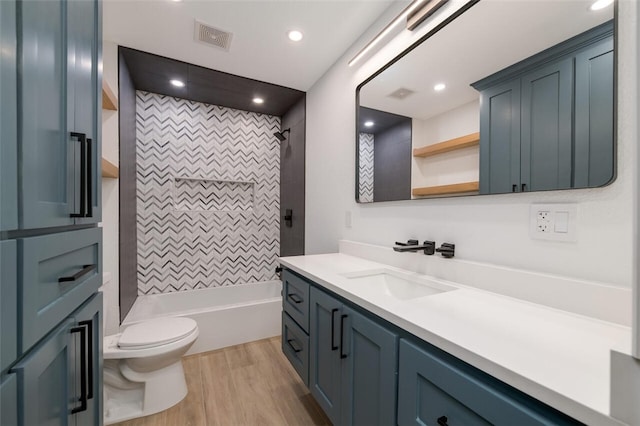 full bathroom with toilet, vanity, tiled shower / bath combo, and hardwood / wood-style flooring