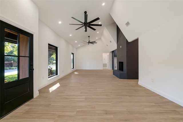 unfurnished living room featuring ceiling fan, light hardwood / wood-style flooring, and high vaulted ceiling