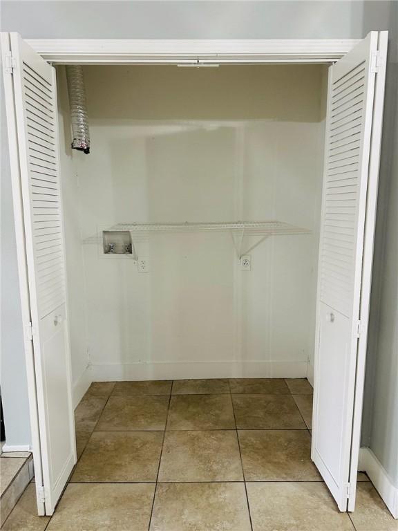 laundry area with washer hookup and light tile patterned floors