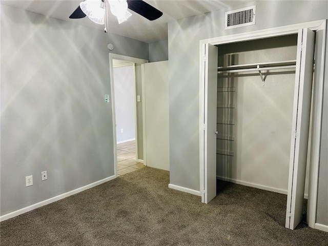 unfurnished bedroom featuring carpet, ceiling fan, and a closet