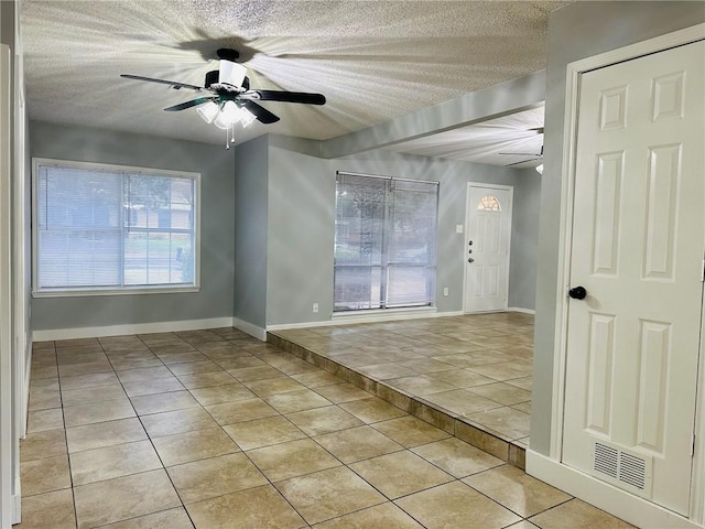 tiled foyer entrance featuring a textured ceiling, a wealth of natural light, and ceiling fan