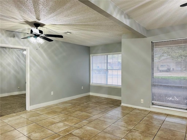 tiled empty room featuring a textured ceiling and ceiling fan