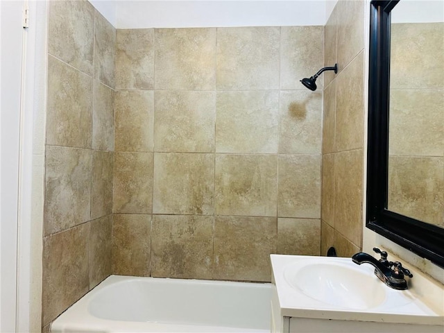 bathroom featuring vanity and tiled shower / bath