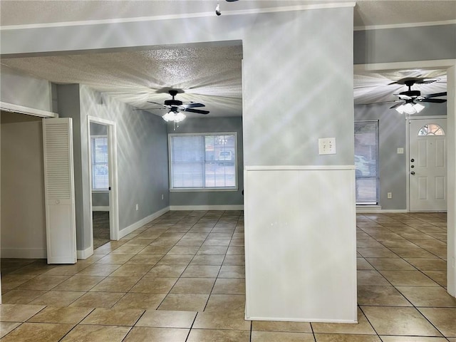 tiled empty room with a healthy amount of sunlight and a textured ceiling