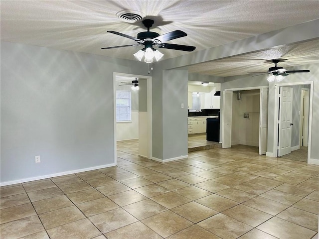 unfurnished room featuring a textured ceiling and light tile patterned flooring