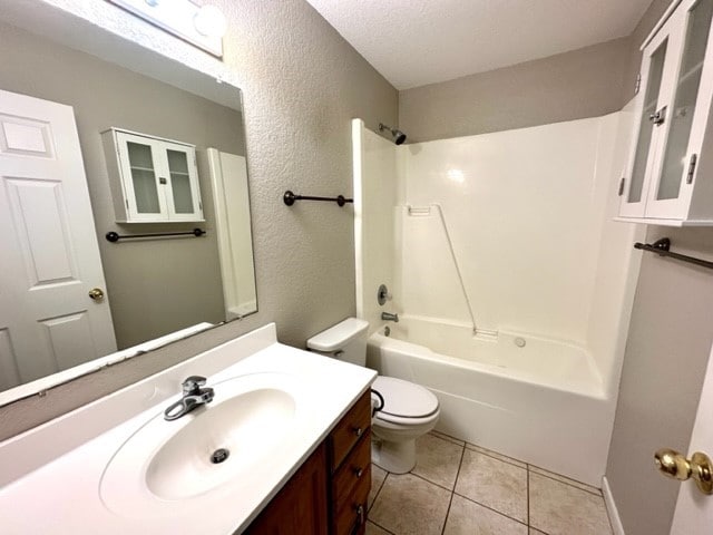 full bathroom featuring vanity, tile patterned flooring, toilet, a textured ceiling, and shower / bathtub combination