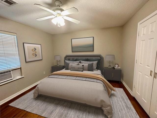 bedroom with a textured ceiling, ceiling fan, and dark wood-type flooring