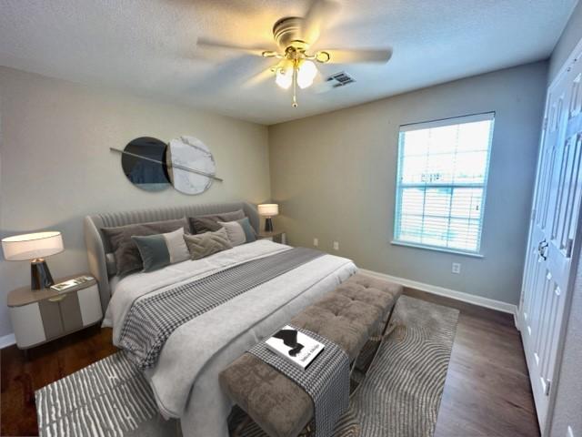 bedroom with ceiling fan, a closet, and dark wood-type flooring