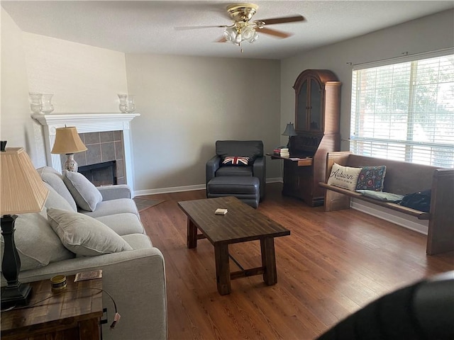 living room featuring a fireplace, dark hardwood / wood-style floors, and ceiling fan