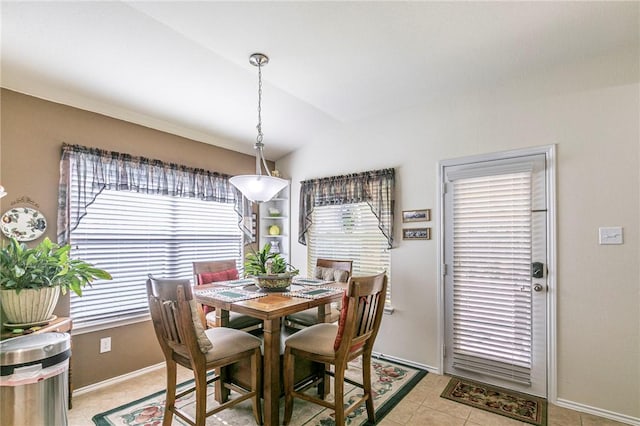 tiled dining area featuring vaulted ceiling