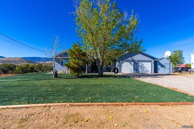 view of front of home featuring a mountain view, a garage, and a front yard