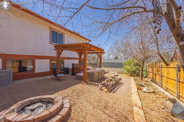 2114 Rangeview Dr, Pueblo, CO 81008 - fenced backyard featuring an outdoor living space with a fire pit, central AC unit, a pergola, and a patio