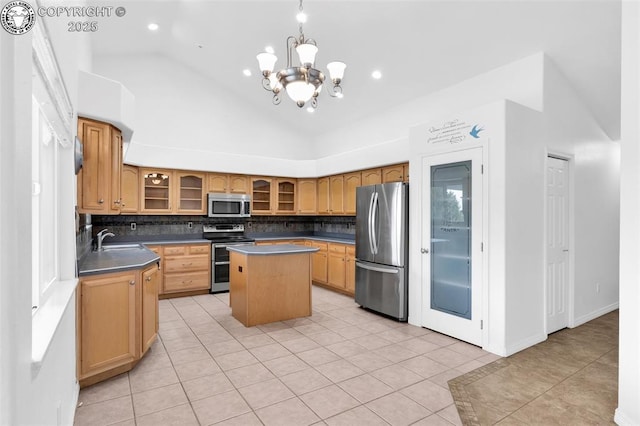 121 Mourning Dove Dr, Canon City, CO 81212 - kitchen with stainless steel appliances, a kitchen island, backsplash, light tile patterned floors, and vaulted ceiling