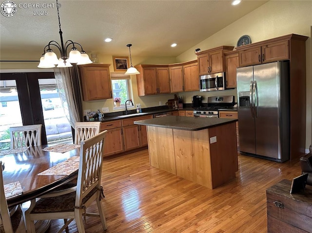 601 Petroleum Ave, Florence, CO 81226 - kitchen featuring stainless steel appliances, dark countertops, a sink, vaulted ceiling, and a kitchen island