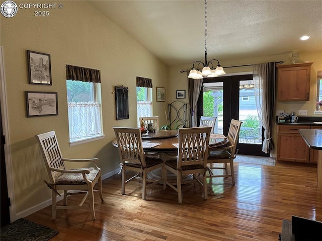 601 Petroleum Ave, Florence, CO 81226 - dining area featuring healthy amount of natural light, light wood finished floors, lofted ceiling, a chandelier, and baseboards