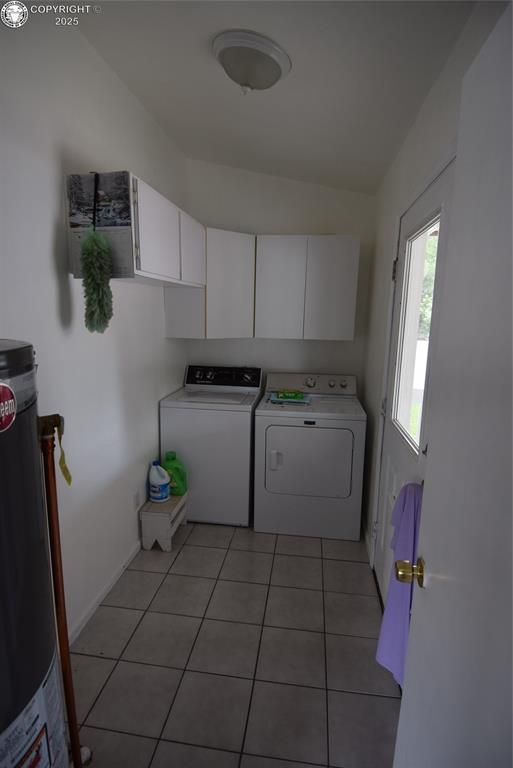 221 Greydene Ave, Canon City, CO 81212 - laundry room with water heater, washing machine and dryer, cabinet space, and light tile patterned floors