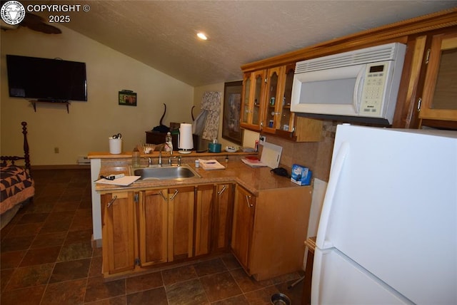 221 Greydene Ave, Canon City, CO 81212 - kitchen featuring white appliances, a peninsula, brown cabinets, vaulted ceiling, and glass insert cabinets
