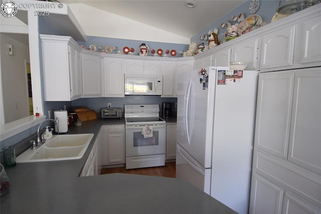 221 Greydene Ave, Canon City, CO 81212 - kitchen featuring white appliances, vaulted ceiling, white cabinetry, dark wood-type flooring, and dark countertops