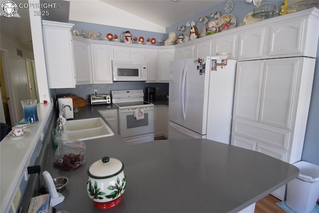 221 Greydene Ave, Canon City, CO 81212 - kitchen featuring white appliances, vaulted ceiling, white cabinetry, and a peninsula