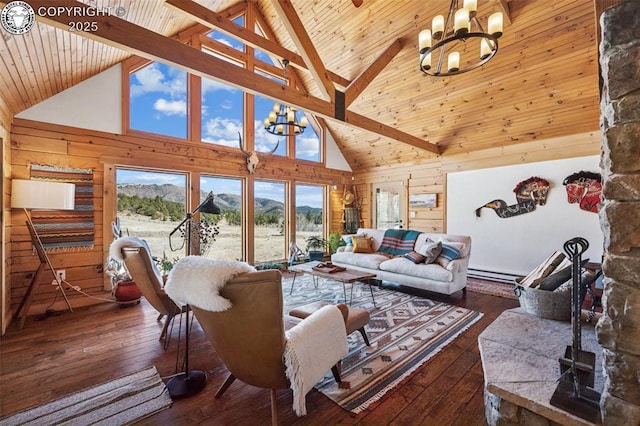 living room featuring high vaulted ceiling, wood walls, a chandelier, and a mountain view