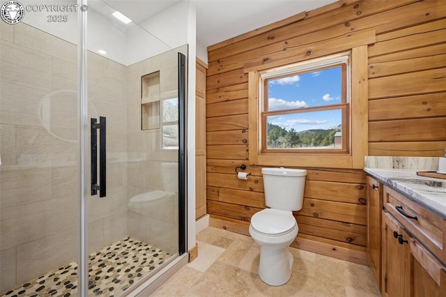full bath with a shower stall, toilet, vanity, and wood walls