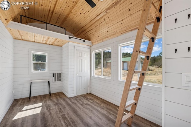 interior space with wood ceiling, lofted ceiling, wood finished floors, and wooden walls