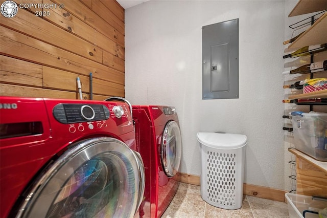 clothes washing area with independent washer and dryer, electric panel, baseboards, and laundry area