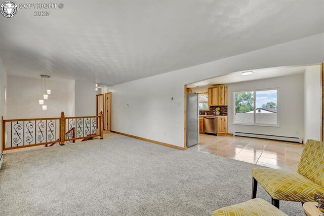 4401 Saint Clair Ave, Pueblo, CO 81005 - unfurnished living room with baseboard heating, light colored carpet, baseboards, and light tile patterned flooring
