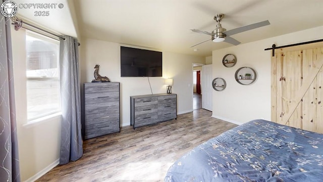 1018 S Camino De Bravo, Pueblo West, CO 81007 - bedroom with a barn door, baseboards, wood finished floors, and a ceiling fan