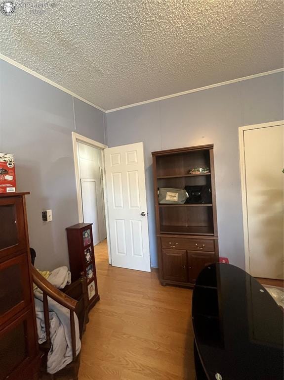 bedroom with a textured ceiling and light hardwood / wood-style flooring