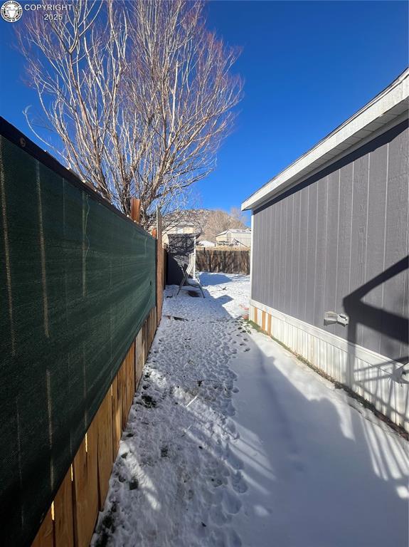 snowy yard with a mountain view and a patio area