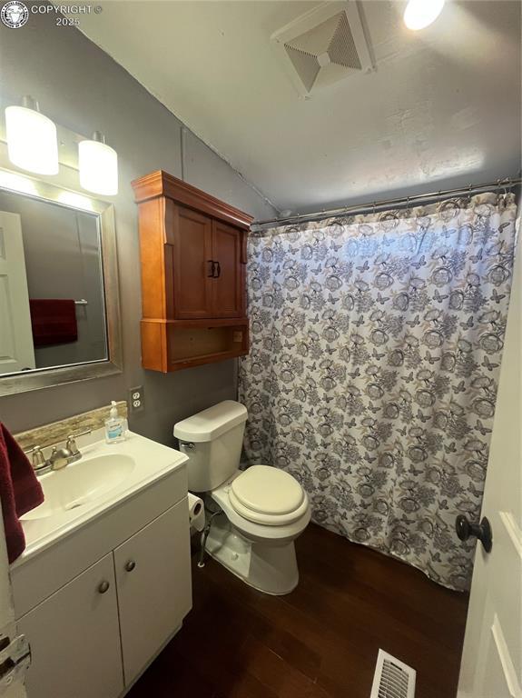 bathroom featuring a shower with curtain, vanity, toilet, and hardwood / wood-style floors