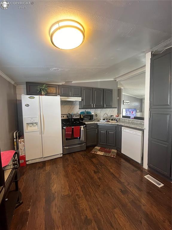 kitchen featuring sink, gray cabinetry, backsplash, stainless steel appliances, and dark hardwood / wood-style floors