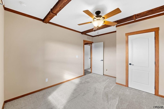 unfurnished bedroom with beamed ceiling, crown molding, light carpet, and ceiling fan