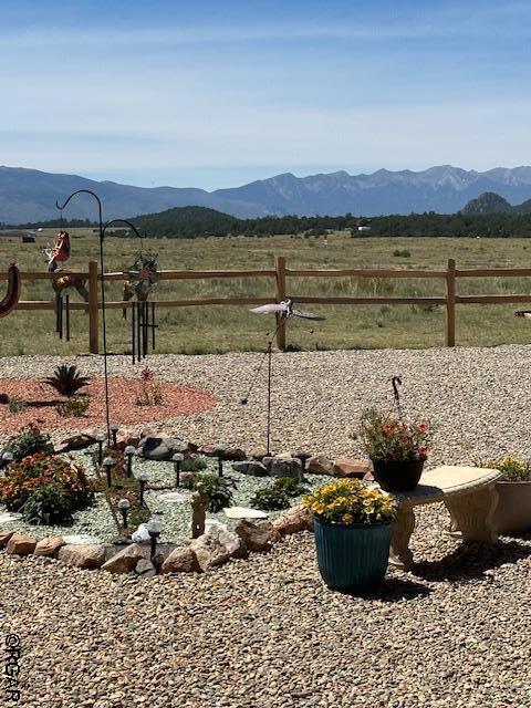 view of yard with a mountain view and a rural view