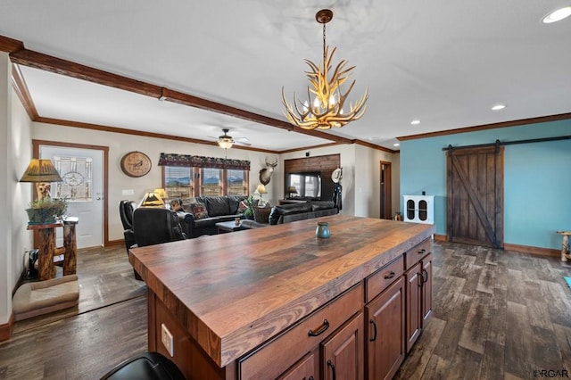 kitchen featuring ornamental molding, a barn door, butcher block counters, and dark hardwood / wood-style floors