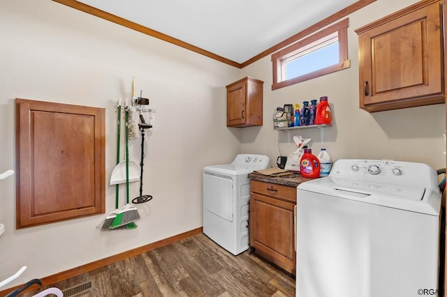 laundry area featuring cabinets, ornamental molding, dark wood-type flooring, and independent washer and dryer