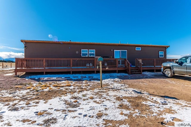 snow covered property featuring a deck