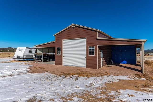 snow covered garage featuring a carport