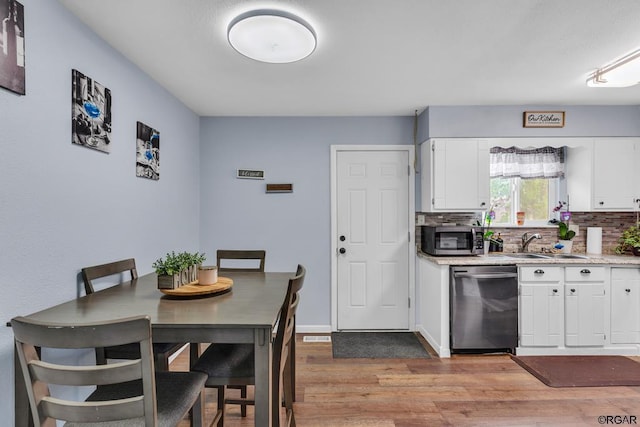 kitchen featuring tasteful backsplash, sink, white cabinets, and appliances with stainless steel finishes