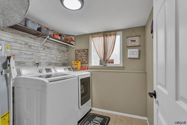 washroom featuring wooden walls, light tile patterned floors, and washer and clothes dryer