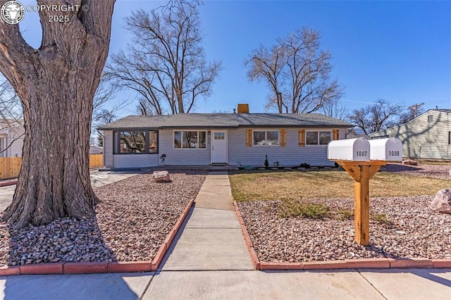 view of front of home with a front yard, fence, and a chimney