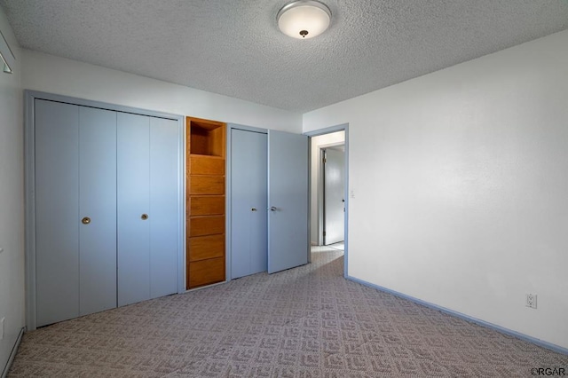 unfurnished bedroom with light carpet and a textured ceiling